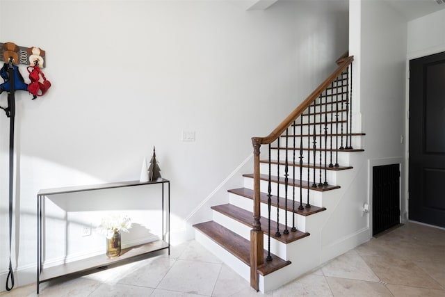 stairway featuring tile patterned flooring