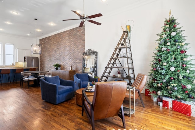 living room featuring hardwood / wood-style flooring, ceiling fan, ornamental molding, and brick wall