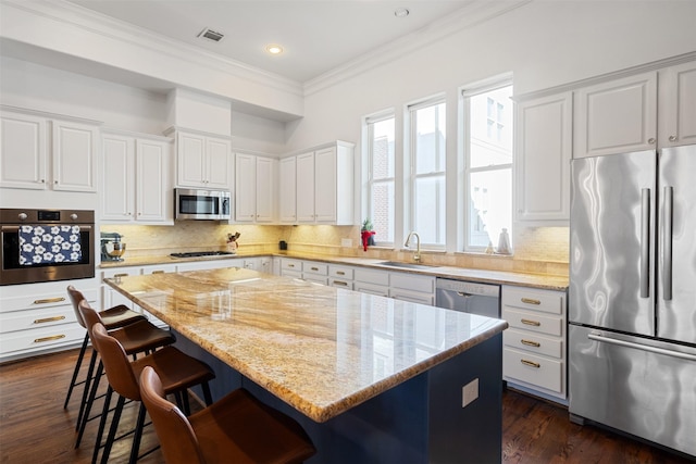 kitchen featuring a center island, dark wood-type flooring, white cabinets, sink, and stainless steel appliances