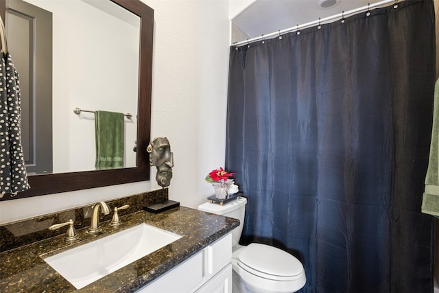 bathroom with a shower with shower curtain, vanity, and toilet