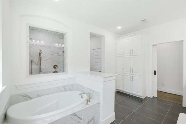 bathroom featuring tiled bath and tile patterned flooring