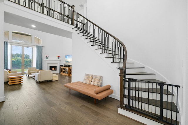 stairway featuring hardwood / wood-style floors and a high ceiling