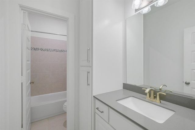 full bathroom with tile patterned floors, tiled shower / bath, vanity, and toilet