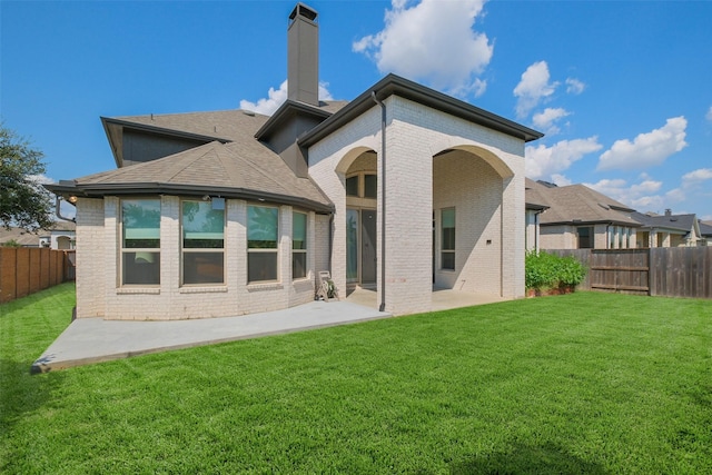 back of house featuring a lawn and a patio