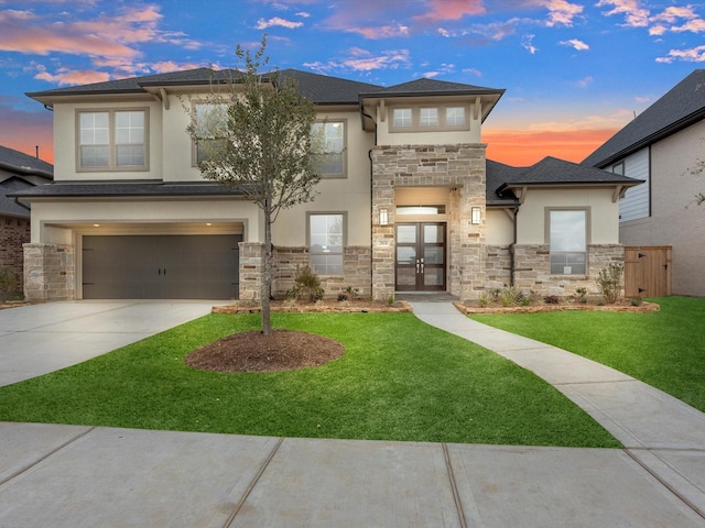 view of front of home featuring a lawn, a garage, and french doors