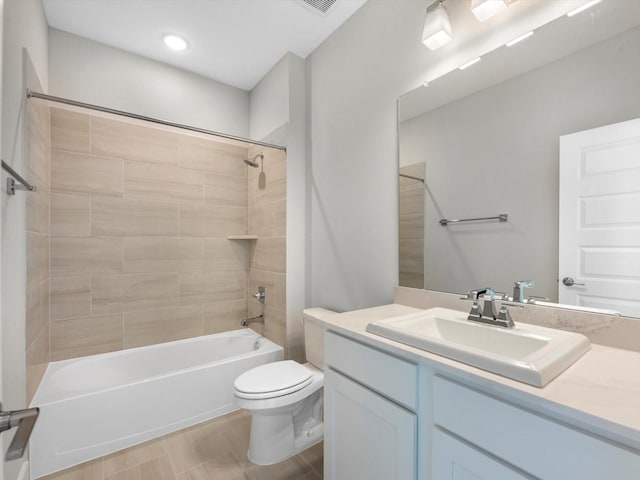 full bathroom with vanity, tiled shower / bath combo, and toilet