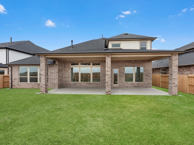 rear view of property featuring a yard and a patio