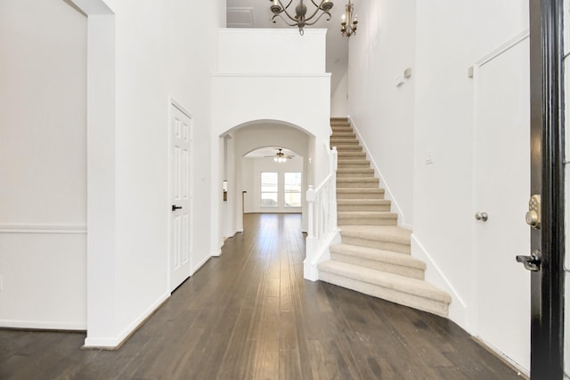 entryway featuring a notable chandelier, dark wood-type flooring, a high ceiling, and french doors