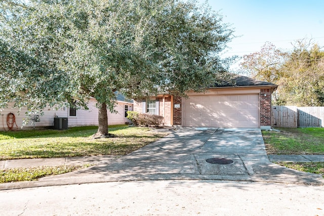 view of front of property with a garage, a front yard, and central AC