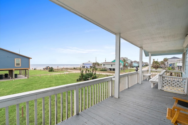 wooden deck featuring a water view and a lawn