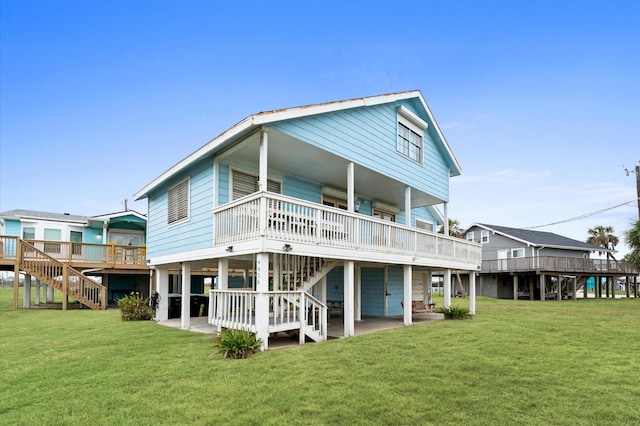 rear view of property featuring a lawn, a patio area, and a wooden deck