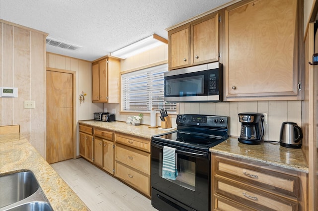 kitchen featuring black electric range oven, light stone countertops, a textured ceiling, and wooden walls