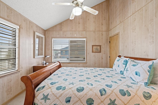 bedroom with a textured ceiling, wooden walls, ceiling fan, and lofted ceiling