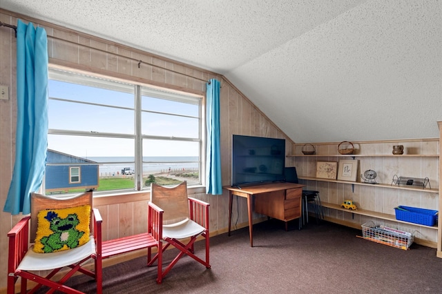 living area featuring carpet flooring, wood walls, a textured ceiling, and vaulted ceiling