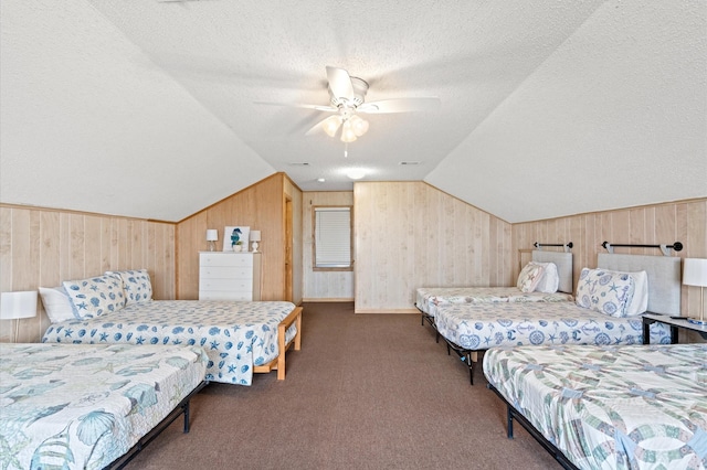 carpeted bedroom featuring a textured ceiling, ceiling fan, lofted ceiling, and wood walls