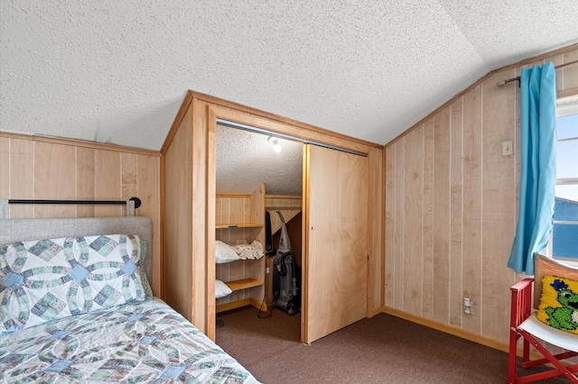 bedroom featuring carpet flooring, lofted ceiling, a closet, and wooden walls