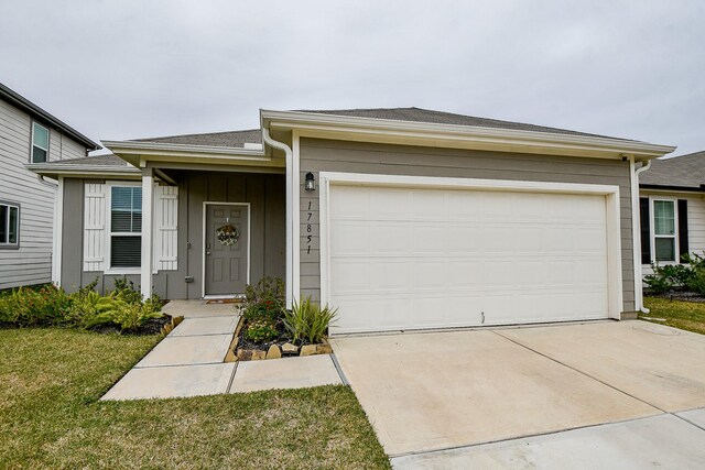 ranch-style house featuring a garage and a front lawn