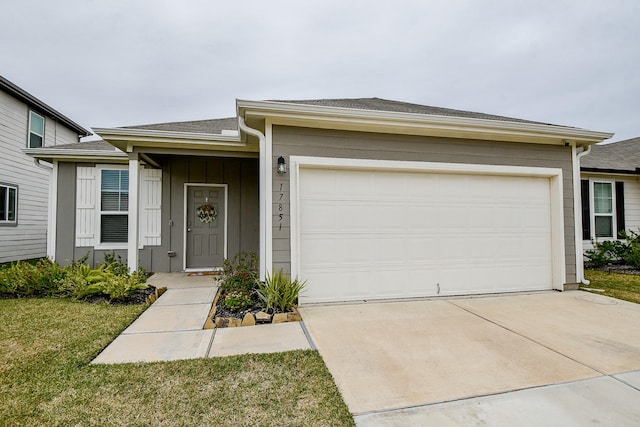 ranch-style home featuring a garage and a front lawn