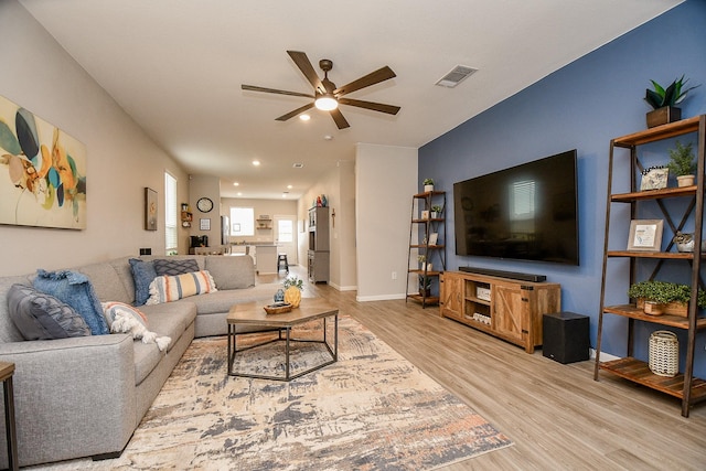 living room featuring light hardwood / wood-style floors and ceiling fan