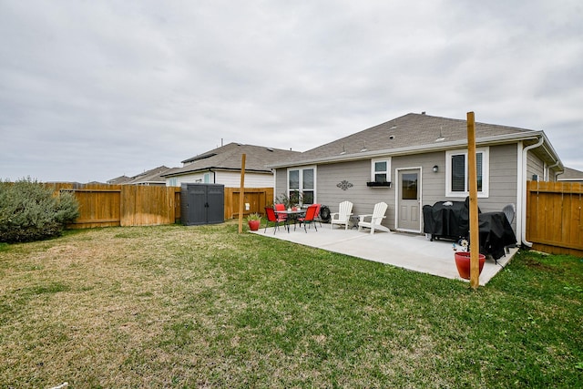 rear view of property featuring a yard, a patio, and a storage shed