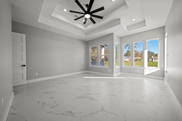 empty room with a tray ceiling and ceiling fan