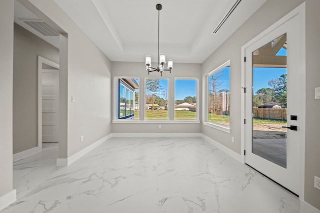 unfurnished dining area featuring a chandelier, a raised ceiling, and a wealth of natural light