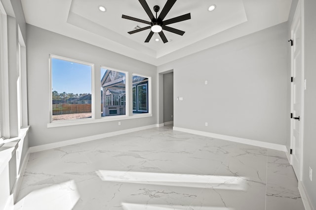 unfurnished room featuring a tray ceiling and ceiling fan