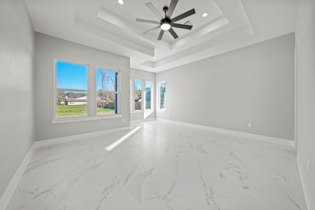 spare room with a raised ceiling and ceiling fan