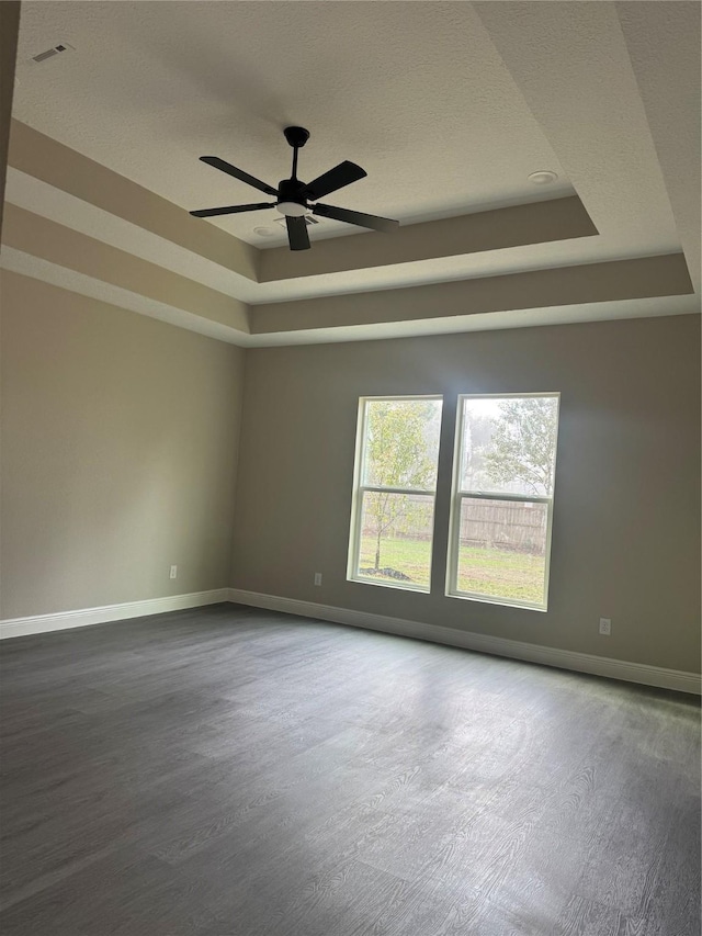 spare room featuring hardwood / wood-style flooring, ceiling fan, and a tray ceiling