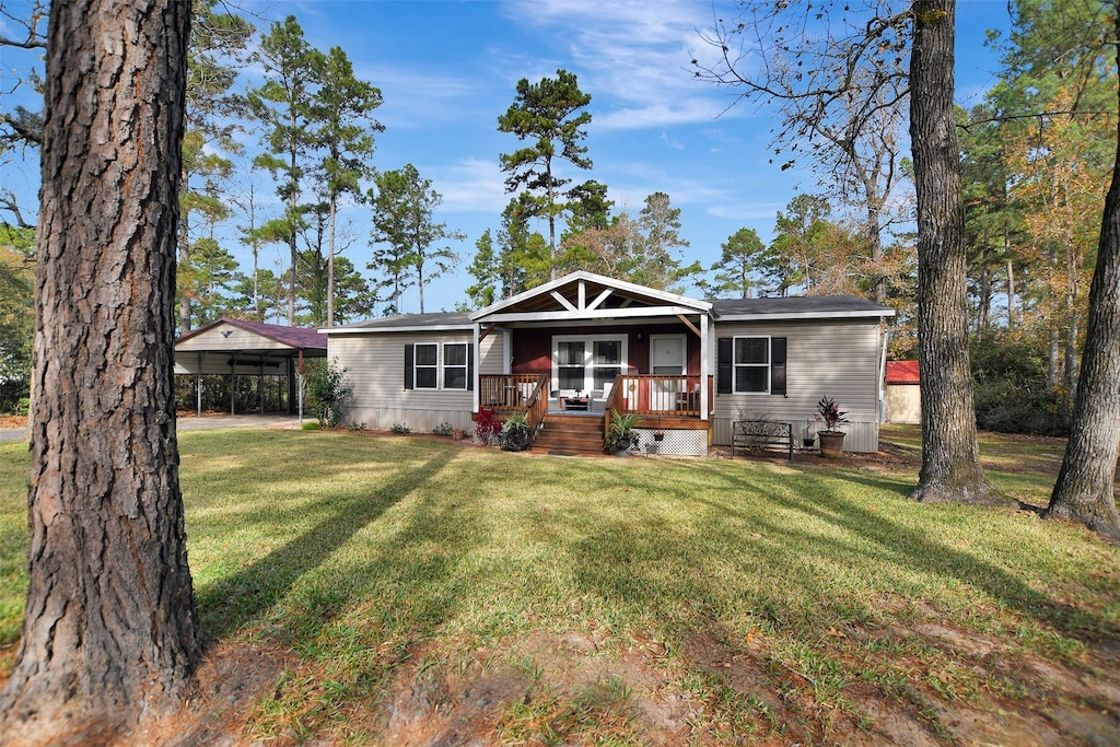 view of front of home with a carport, a porch, and a front yard