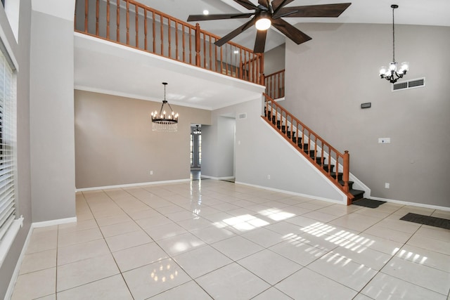 unfurnished living room featuring ceiling fan with notable chandelier, ornamental molding, light tile patterned floors, and high vaulted ceiling