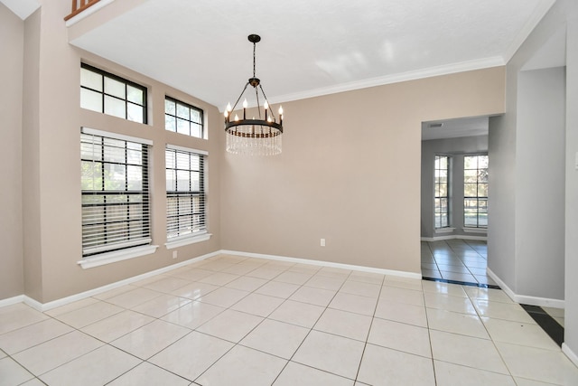 tiled empty room with a chandelier and crown molding