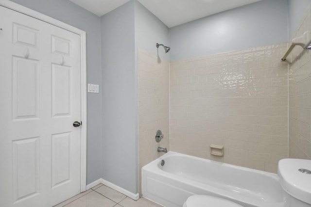 bathroom with tile patterned floors, toilet, and tiled shower / bath