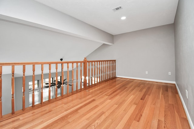 bonus room featuring light hardwood / wood-style floors and vaulted ceiling with beams