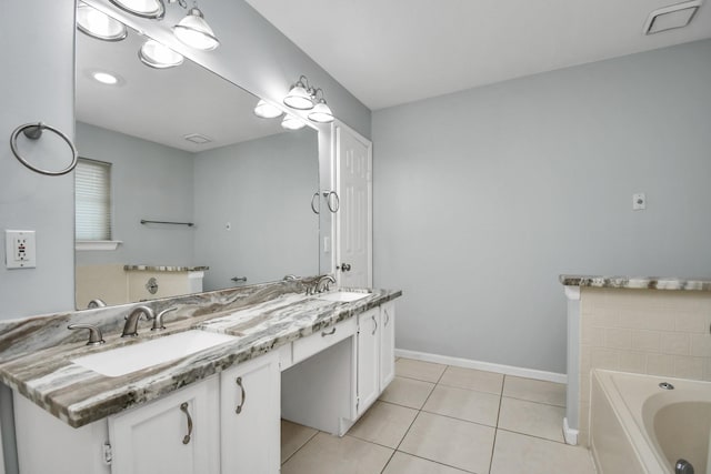 bathroom with tile patterned flooring, a tub to relax in, and vanity