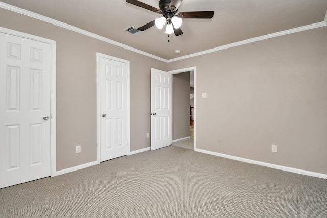 unfurnished bedroom featuring ceiling fan, crown molding, and carpet floors