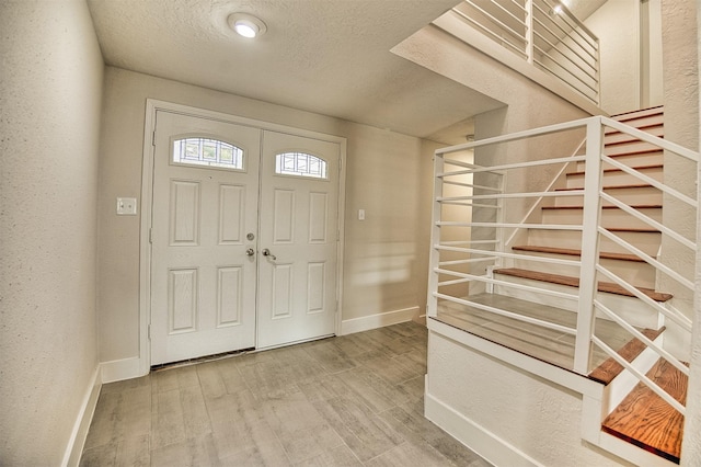 entrance foyer with wood-type flooring and a textured ceiling