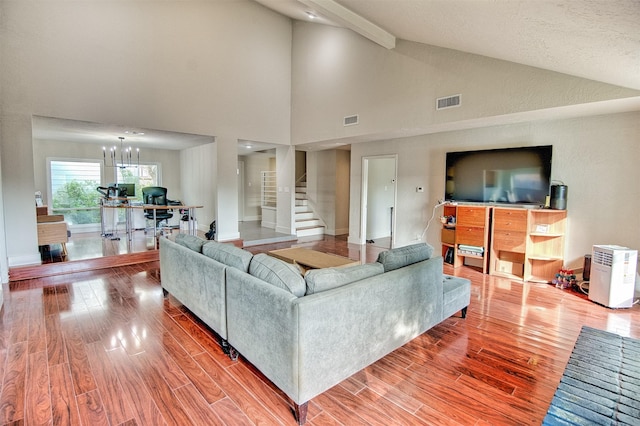 living room featuring a chandelier, wood-type flooring, and lofted ceiling