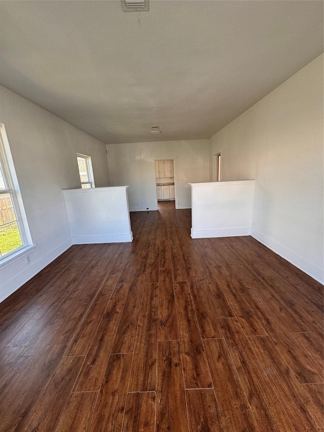 unfurnished room featuring a healthy amount of sunlight and dark hardwood / wood-style floors