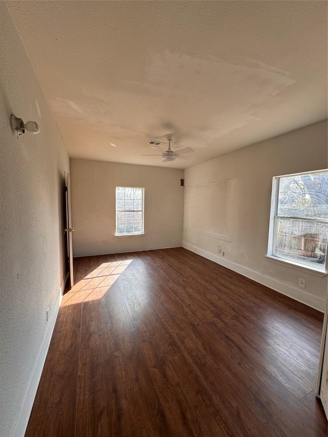 unfurnished room with dark hardwood / wood-style flooring and ceiling fan