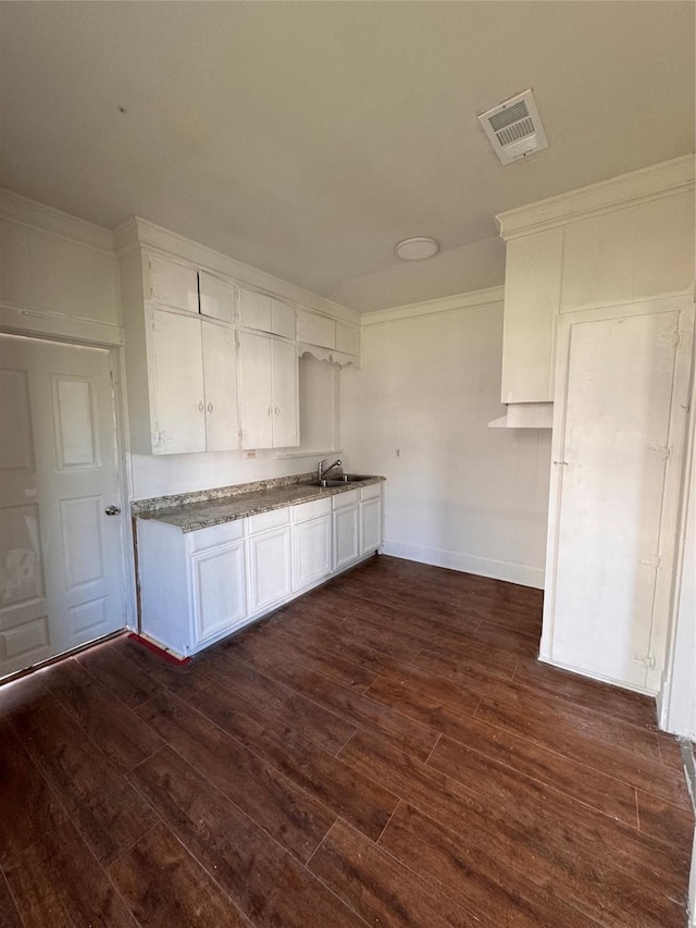 kitchen featuring crown molding, dark hardwood / wood-style flooring, white cabinetry, and sink