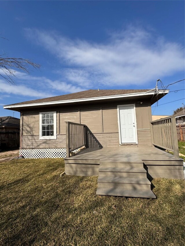 back of property with a yard and a deck