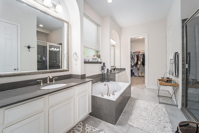 bathroom with tile patterned flooring, vanity, and shower with separate bathtub