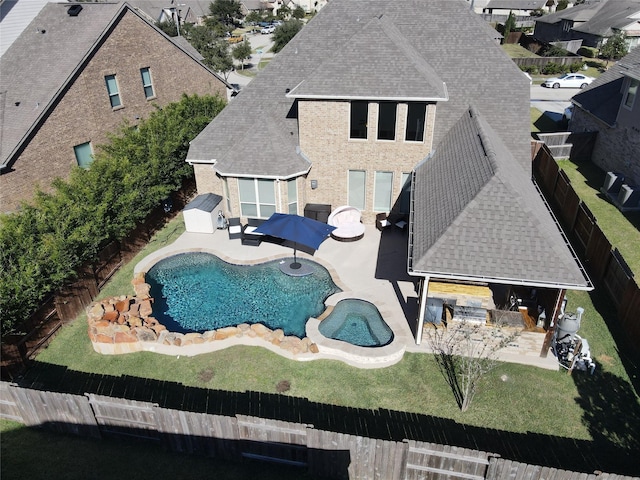 view of swimming pool featuring an outdoor kitchen, exterior bar, a patio area, and a lawn