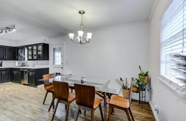 dining area featuring a notable chandelier, wood-type flooring, and ornamental molding