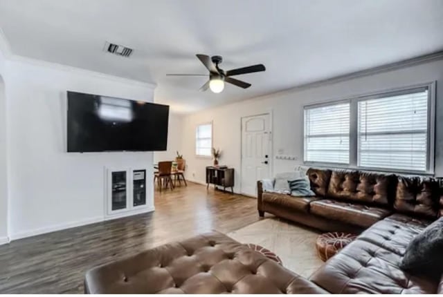 living room with ceiling fan, crown molding, and wood-type flooring