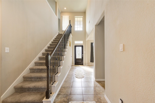 tiled entrance foyer featuring a towering ceiling