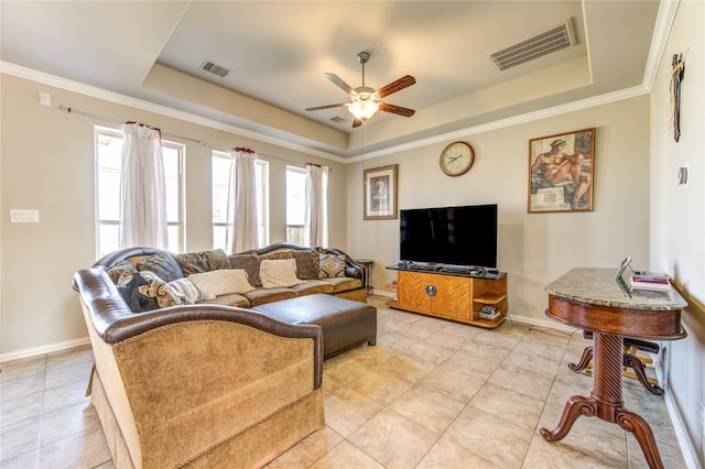 tiled living room with a tray ceiling, ceiling fan, and crown molding