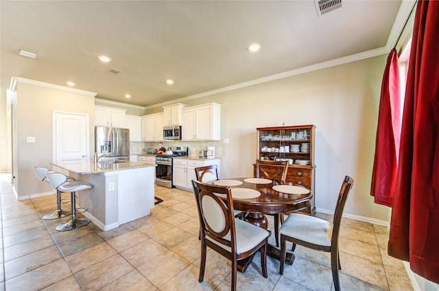 kitchen featuring a kitchen island with sink, sink, light stone countertops, white cabinetry, and stainless steel appliances