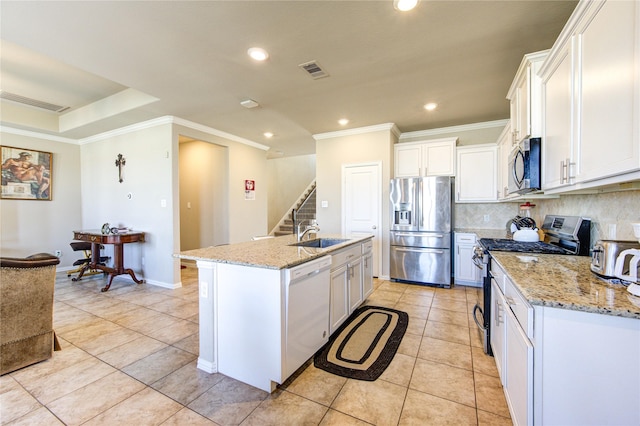 kitchen with a center island with sink, white cabinets, light tile patterned floors, and appliances with stainless steel finishes